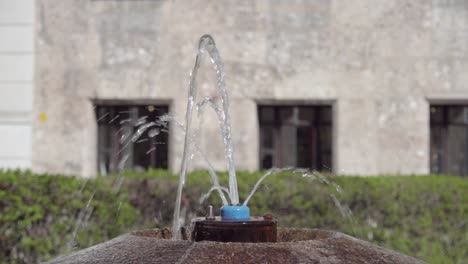 Water-splashing-out-of-a-small-water-fountain-faucet-on-Domplatz-square-in-the-city-centre-of-Innsbruck,-North-Tyrol,-Austrial