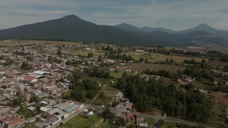 Aerial-drone-shot-in-Mexico-Michoacan,-with-forest-and-old-town-background