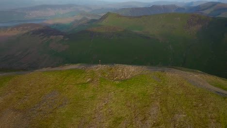 Distant-lone-mountain-walker-on-summit-ridge-path-at-golden-hour