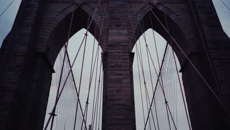 Brooklyn-Bridge-Pfeiler-In-Der-Abenddämmerung,-Schwenk-Nach-Unten-Zum-Fußweg-Voller-Menschen