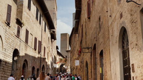 Turistas-Caminando-En-Un-Histórico-Callejón-Toscano-Con-Edificios-Medievales.