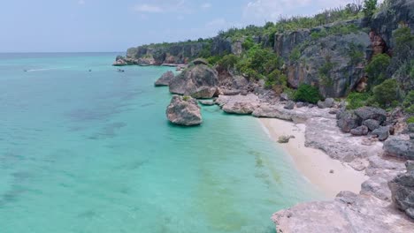 Picturesque-Caribbean-Sea-coastline-with-rocks-and-beach-in-sunlight