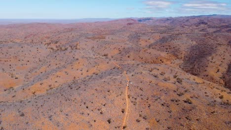 High-altitude-drone-footage-over-vehicles-parked-on-a-hill-in-the-Flinders-Ranges,-Australia