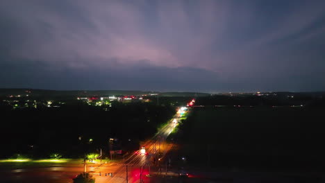 Lightning-storm-over-Springdale,-Arkansas-at-night-with-illuminated-city-streets