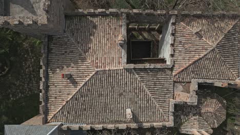 Top-down-shot-drone-ascending-from-the-Castle-of-Perafita-in-Catalonia,-Spain