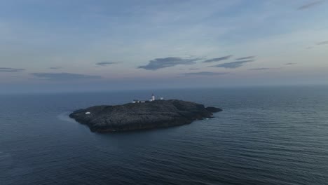 Slowly-approaching-Marsteinen-Lighthouse-with-misty-horizon-and-a-gloomy,-spooky-atmosphere-over-vast-Atlantic-Ocean