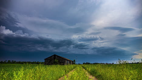 Gewitterwolken-über-Einer-Alten,-Verlassenen-Scheune-Auf-Dem-Land---Dramatische-Wolkenlandschaft-Im-Zeitraffer