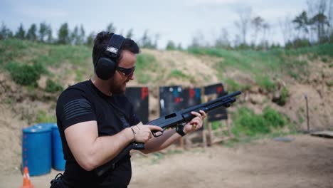 Muscular-caucasian-male-hold-and-reload-shotgun-at-Olesko-shooting-range