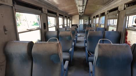 Chairs-Of-An-Abandoned-Train-In-Peloponnese,-Greece---Tilt-Up-Shot