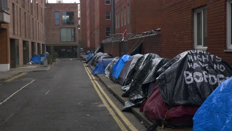 Row-of-tents-lining-an-urban-street-in-Dublin,-highlighting-the-city's-housing-crisis-and-homeless-situation