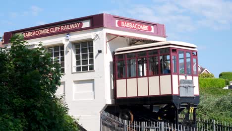 Babbacombe-Cliff-Railway-train-car-with-people-traveling-down-to-popular-Oddicombe-Beach-in-Torquay,-Devon,-England-UK