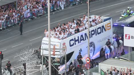 Real-Madrid-players-ride-on-a-bus-as-they-celebrate-winning-their-15th-UEFA-Champions-League-trophy-at-Cibeles-Square,-where-thousands-of-fans-have-gathered-to-witness-the-celebratory-parade-in-Madrid