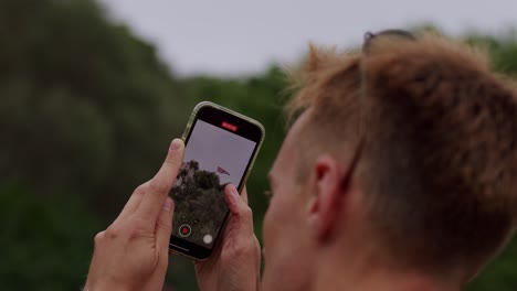 Closeup-shot-of-a-man-capturing-beauty-of-Gibraltar-by-his-phone-during-daytime-in-England