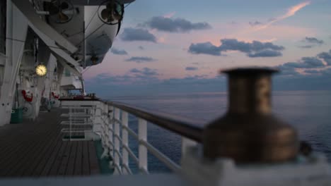 Ship-Bollard-on-Open-Side-Deck-with-Hand-Railing-On-Board-of-a-Cruise-Ship-Ferry-during-Sunset,-Rack-Focus-Shift-Close-Up