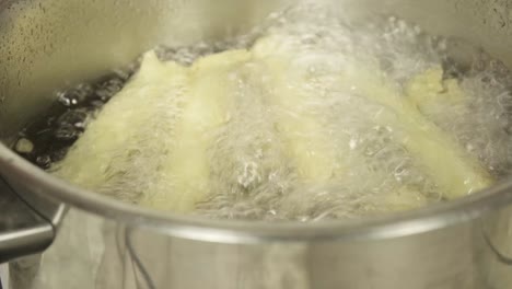 Close-shot-of-white-cauliflowers-being-boiled-in-a-pot-of-water