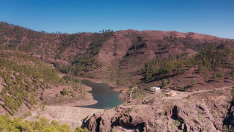 Drone-Aéreo-Volando-Sobre-Una-Presa-Sobre-Un-Embalse-De-Lago-En-Las-Montañas-De-Gran-Canaria-España