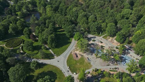 Flying-over-Plikta-playground-in-Slottsskogen-city-park-and-to-the-left-is-the-Slottsskogen-Labyrinth-in-Gothenburg,-Sweden