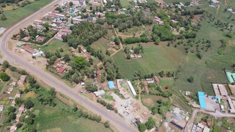 Modern-highway-passing-poor-African-village-in-Kenya,-aerial-view