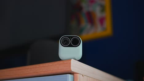 slow-zoom-in-on-small-home-security-camera-with-TV-playing-in-background