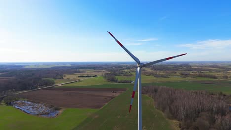 drone-footage-of-wind-turbines-in-a-wind-farm-generating-green-electric-energy-on-a-wide-green-field-on-a-sunny-day,-in-Taurage,-Lithuania