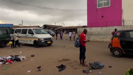 Trostlosigkeit-Am-Busbahnhof,-In-Der-Nähe-Von-Cape-Coast,-Ghana,-Müll-Und-Staub,-Während-Reisende-Auf-Das-Fahrzeug-Warten