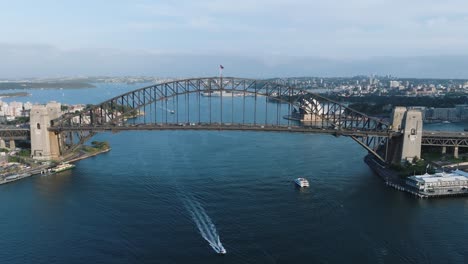 Sydney,-Australia---31-De-Marzo-De-2024:-El-Puente-Del-Puerto,-Un-Emblemático-Puente-De-Acero-A-Través-De-Arco,-Con-Barcos-Rápidos-Y-Barcos-Que-Pasan-Por-Debajo