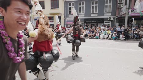 Kukeri-Mummer-Baila-Con-Un-Feliz-Espectador-Asiático-En-El-Desfile-Del-Festival-De-Las-Rosas