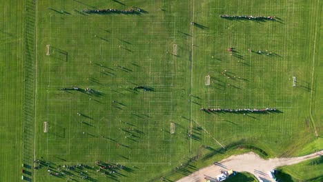 Vista-Aérea-Timelapse-De-Personas-Jugando-En-Tres-Campos-De-Fútbol-En-Un-Día-De-Verano-Al-Atardecer