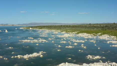 Luftaufnahme-Des-Mono-Lake-Mit-Seinen-Ikonischen-Tuffsteintürmen,-Die-Aus-Dem-Wasser-Ragen,-Umgeben-Von-Einer-Ausgedehnten-Wüsten--Und-Berglandschaft-Unter-Einem-Hellen,-Sonnigen-Himmel