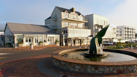 Iconic-whale-tail-fountain-in-Hermanus-at-sunrise,-real-time-pan-shot