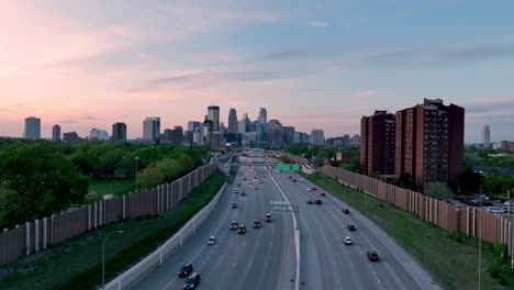 Aerial-approach-over-highway-I-35W-toward-Minneapolis-skyline-at-twilight