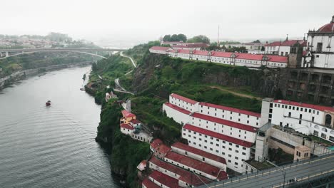 Aerial-view-of-the-historic-Serra-do-Pilar-Monastery-in-Vila-Nova-de-Gaia,-Porto,-with-red-roofed-buildings-and-lush-greenery