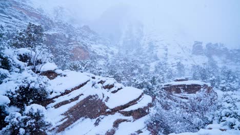 Wide-shot-of-the-thick-snowfall-raining-down-on-the-mountains-of-Zion-California