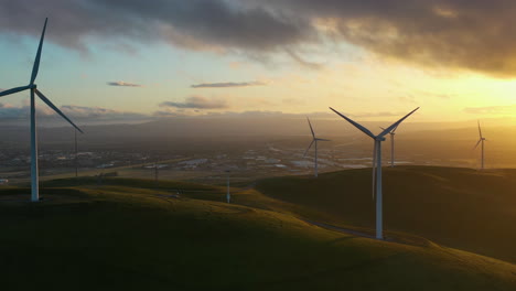 Wind-power-plant-in-the-highlands,-colorful-evening-in-USA---Aerial-view