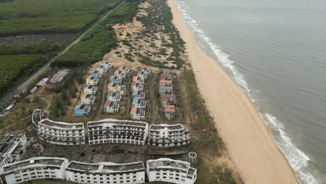 High-Angle-Drone-Shot-Of-Abandoned-Resort-And-Villas-On-Empty-Vietnam-Beach-60FPS