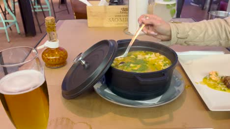 Vista-Cercana-De-Una-Mujer-Elegante-Sirviéndose-Un-Plato-De-Arroz-Con-Mariscos,-Todavía-Muy-Caliente.