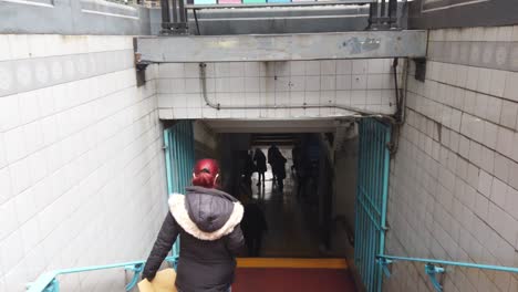 POV-red-haired-woman-goes-down-underground-staircase,-enters-metro-station-going-downstairs-in-buenos-aires-city,-argentina-public-transport