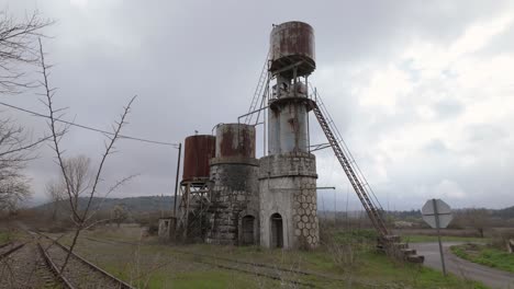 Old-Rusty-Silos-Near-Abandoned-Railway-Tracks-In-Northern-Peloponnese,-Greece