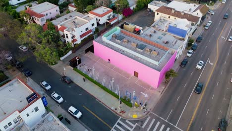 Flying-Over-Famous-Pink-Wall-on-Melrose-Avenue-in-West-Hollywood,-California,-Daytime-Shot-of-Popular-Photo-Spot