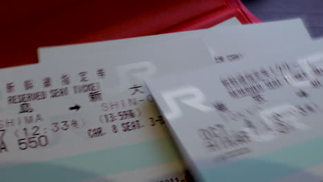 Nahaufnahme-Eines-21-Tages-Japan-Rail-Passes-In-Einer-Roten-Brieftasche-Mit-Darauf-Geworfenen-Reservierungstickets