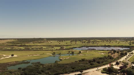 A-drone-panning-laterally,-capturing-the-beauty-of-a-golf-course-in-South-America-during-a-stunning-sunset