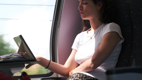 Young-woman-reading-an-ebook-while-traveling-by-train