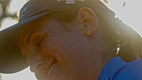 Women-in-50s-with-Cap-Looking-at-Camera-and-Smiles,-Low-Angle-Viee