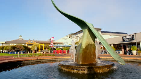 Sunrise-shot-of-walking-group-passing-iconic-Hermanus-whale-tail-fountain-in-CBD