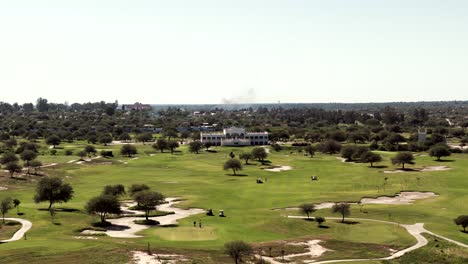 A-panoramic-view-of-the-Termas-De-Rio-Hondo-Golf-Club,-bustling-with-people-enjoying-a-game-of-golf-on-a-beautiful-sunny-day