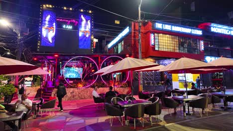 Vibrant-nightlife-scene-in-El-Poblado,-Medellin,-with-bright-lights-and-outdoor-seating-at-night