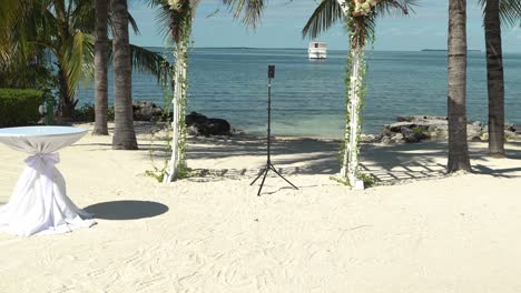 Plano-En-Movimiento-Hacia-Adelante-Lugar-Para-Celebrar-Bodas-Junto-A-La-Playa-En-Un-Día-Soleado-Con-Paz-Y-Tranquilidad-Asientos-Al-Aire-Libre-Playa-De-Arena-Asientos-Para-Compromiso-Con-Mesas