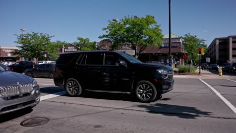 Downtown-Dearborn,-Michigan-intersection-with-traffic-driving-by-with-panning-right-to-left