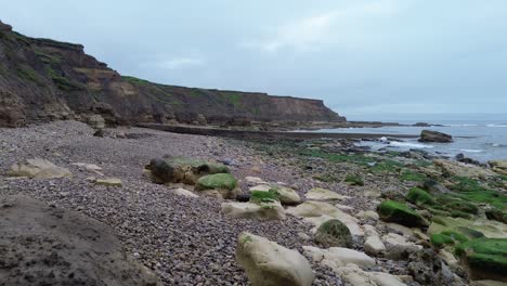 Drone-shot-flying-through-rocky-arch-revealing-stunning-Northeast-English-coastline