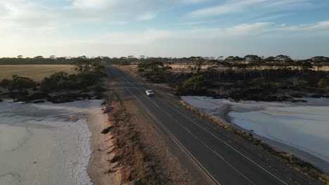 Auto-Fährt-Auf-Landstraße-über-Ausgetrockneten-Salzsee,-Westaustralien